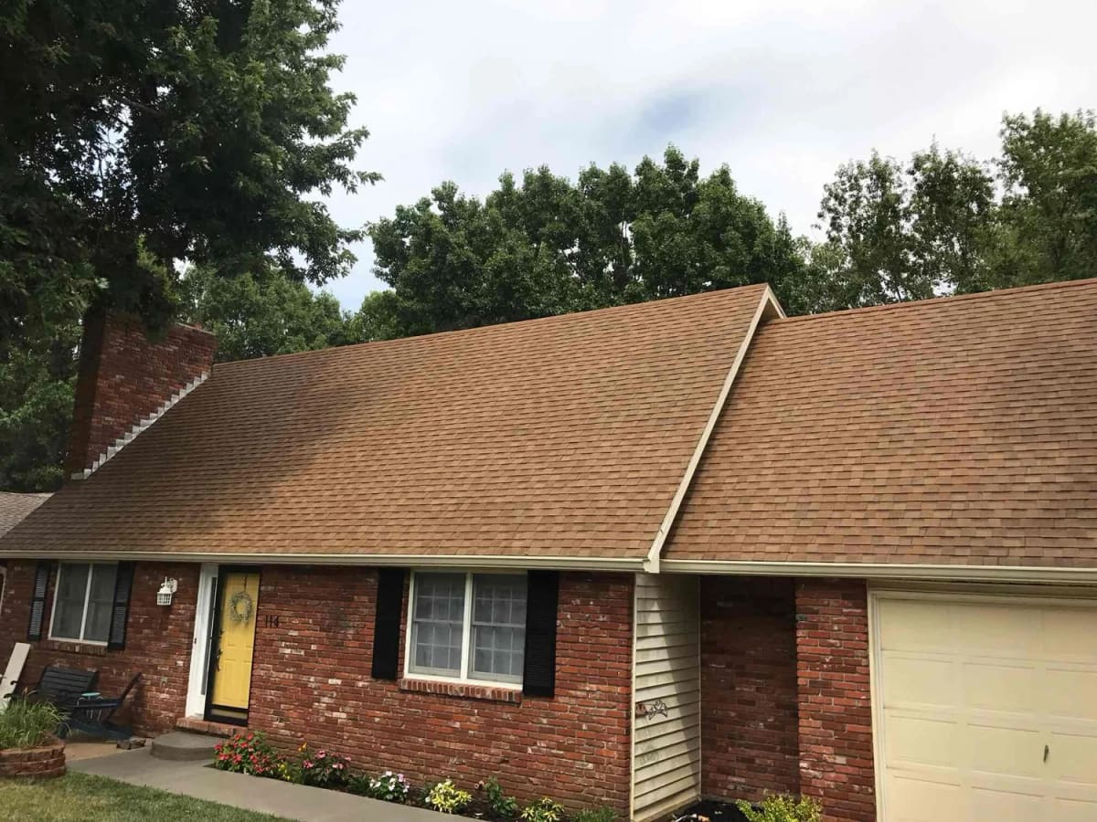 The same brick ranch home after house washing, roof cleaning and concrete cleaning in one visit